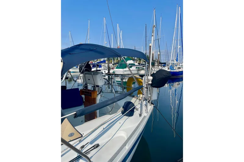 Slide: The Image of 1986 Ericson 35.3 sailboat docked in a marina with clear blue skies. - 5