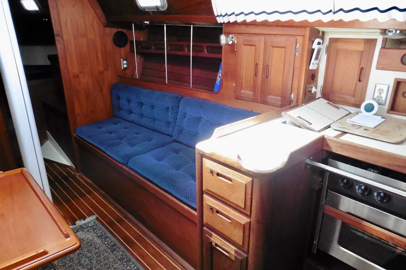 Slide: The Image of Interior of 1986 Ericson 35.3 sailboat with wooden cabinetry and blue cushioned seating. - 23