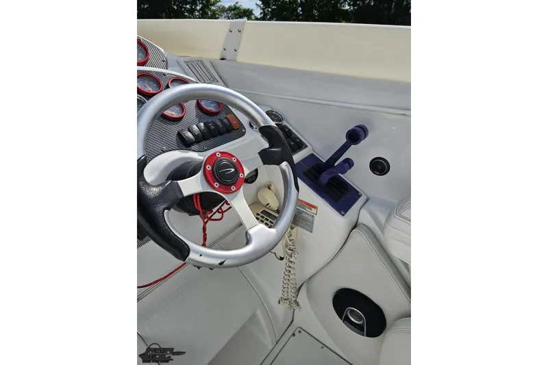 Slide: The Image of Steering wheel and controls of a 2003 Baja 342 boat cockpit. - 54