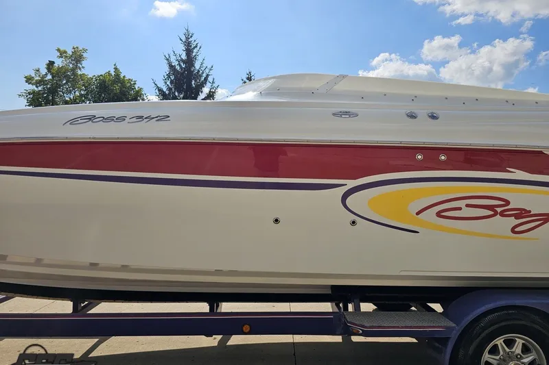 Slide: The Image of 2003 Baja 342 boat with vibrant red and yellow graphics on a sunny day. - 21
