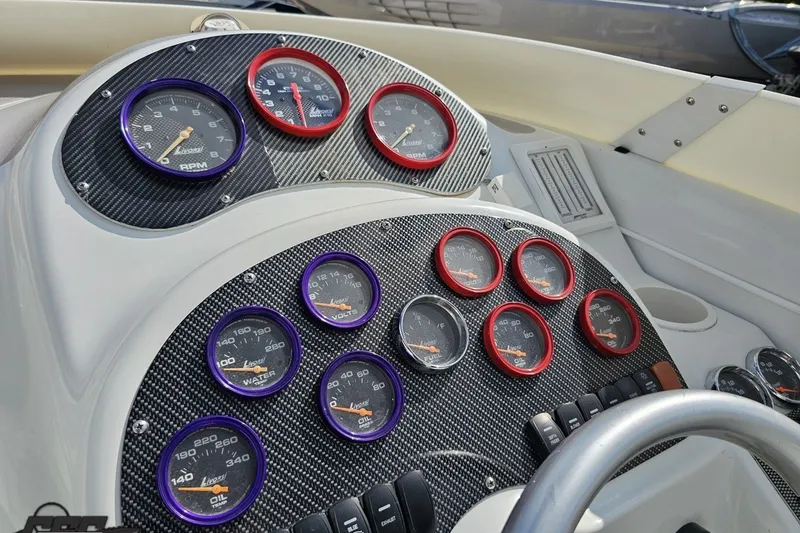 Slide: The Image of Dashboard of a 2003 Baja 342 boat with multiple gauges and carbon fiber finish. - 50