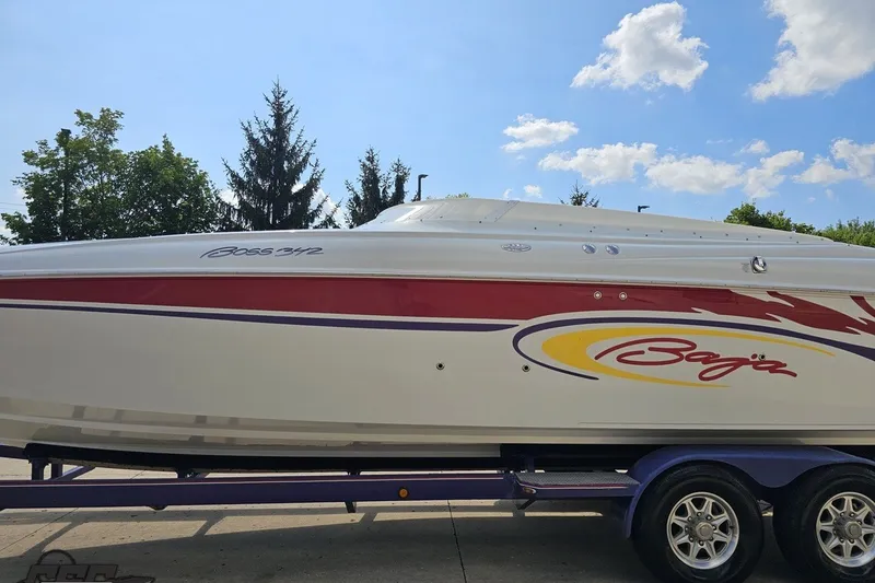 Slide: The Image of 2003 Baja 342 boat with vibrant graphics on a trailer under a clear sky. - 18
