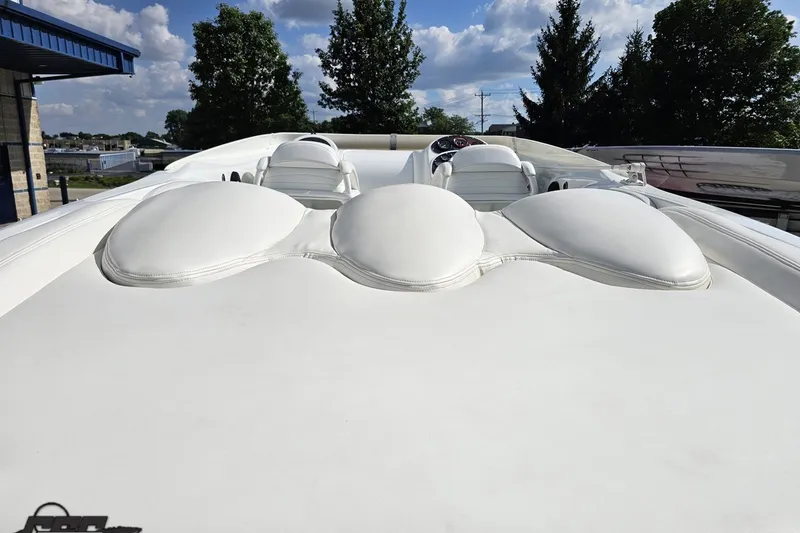 Slide: The Image of 2003 Baja 342 boat with white cushioned seating, outdoors under a blue sky. - 31
