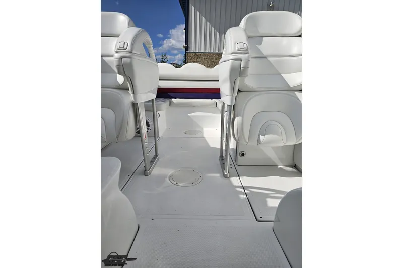 Slide: The Image of Interior of a 2003 Baja 342 boat with white seating and clear sky background. - 69