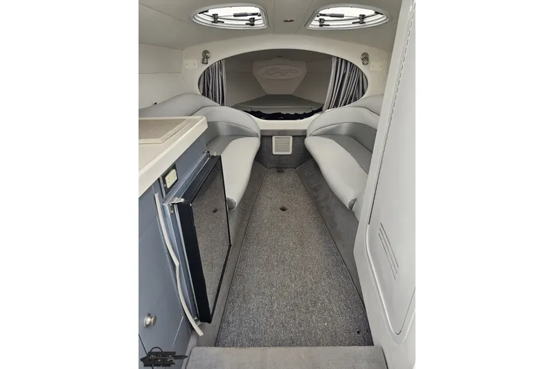 Slide: The Image of Interior of a 2003 Baja 342 boat, featuring seating and compact kitchenette. - 58