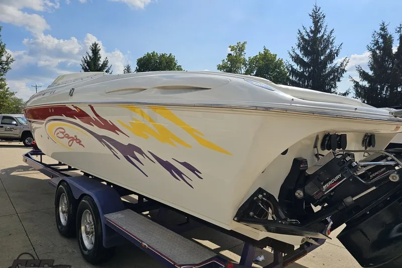 Slide: The Image of 2003 Baja 342 speedboat with colorful graphics on a trailer, parked outdoors. - 25