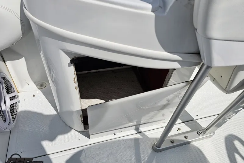 Slide: The Image of Open storage compartment on a 2003 Baja 342 boat deck, featuring white interior and speaker. - 86