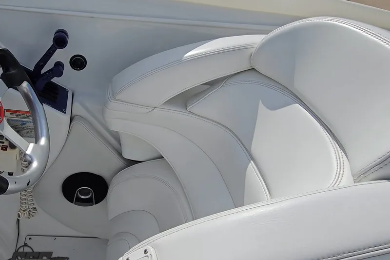 Slide: The Image of White leather seating and steering area of a 2003 Baja 342 boat. - 47