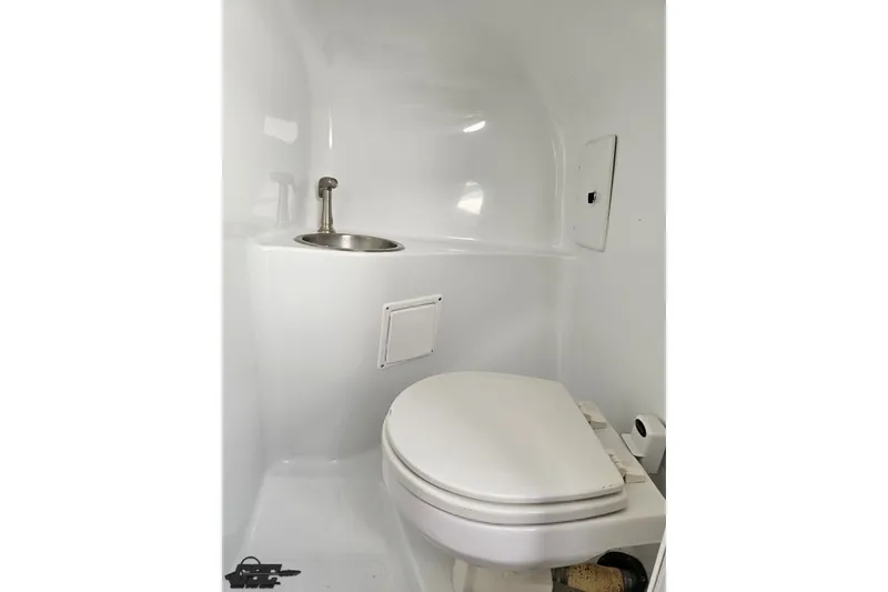 Slide: The Image of Compact bathroom in a 2003 Baja 342 boat, featuring a toilet and sink. - 63
