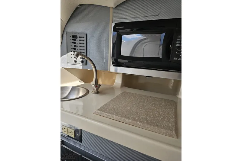 Slide: The Image of 2003 Baja 342 boat interior with sink, microwave, and control panel. - 68