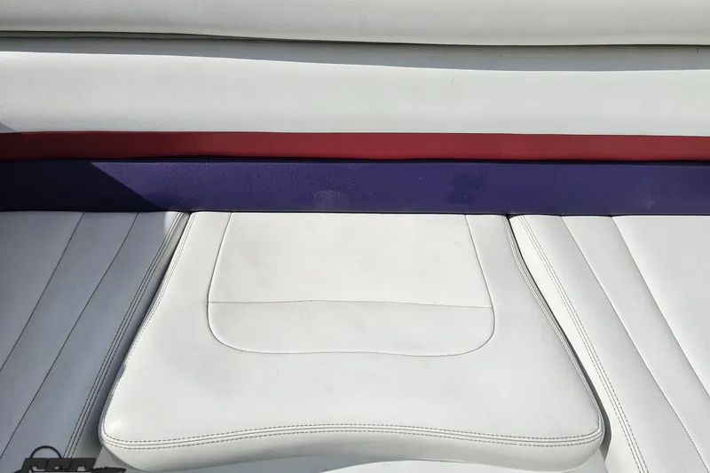 Slide: The Image of White leather seating with red and purple accents on a 2003 Baja 342 boat. - 76