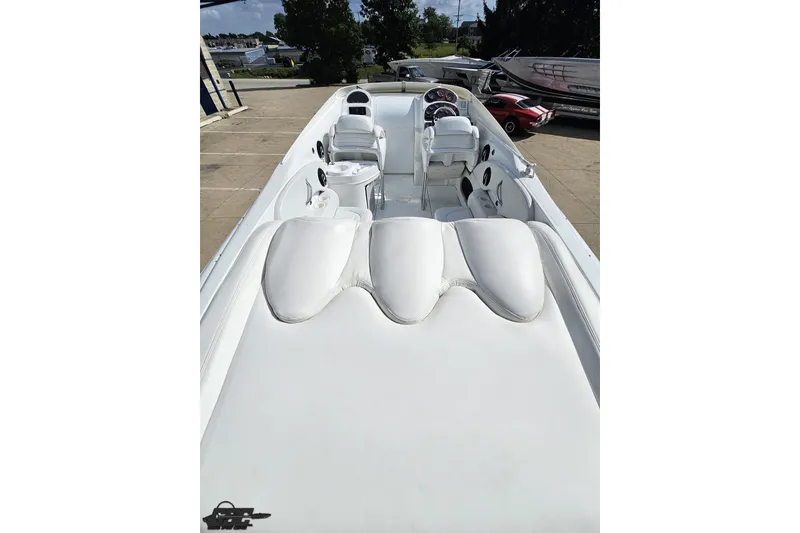 Slide: The Image of 2003 Baja 342 boat interior with white seating and dashboard, parked outdoors. - 32