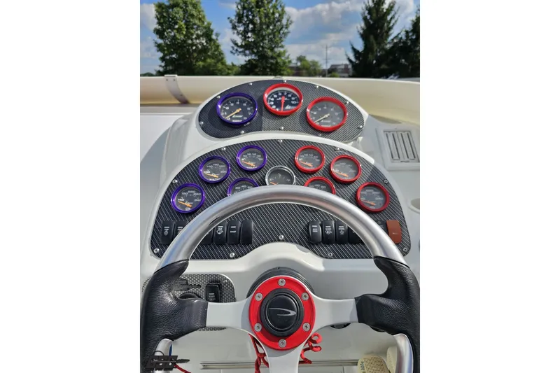 Slide: The Image of Dashboard of a 2003 Baja 342 boat with colorful gauges and steering wheel. - 52