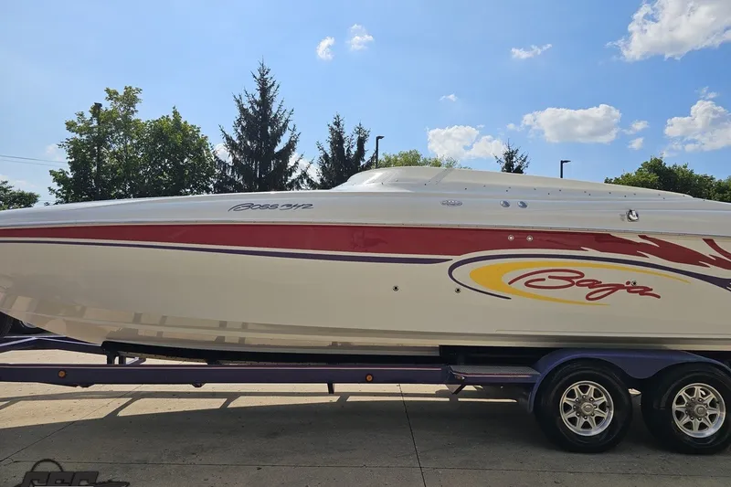 Slide: The Image of 2003 Baja 342 boat with vibrant graphics on a trailer under a clear sky. - 19
