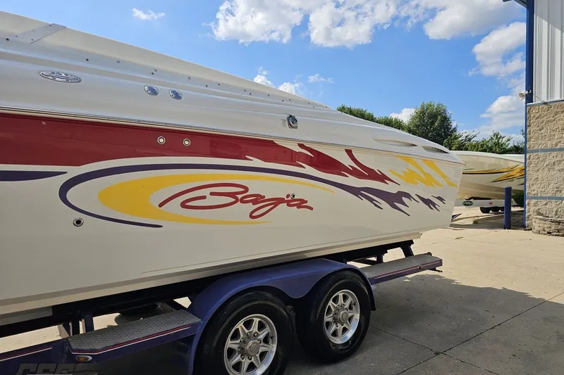 Slide: The Image of 2003 Baja 342 boat with colorful graphics on a trailer under a blue sky. - 20