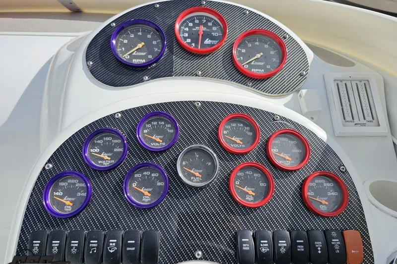 Slide: The Image of Dashboard of a 2003 Baja 342 boat with multiple gauges and switches. - 53