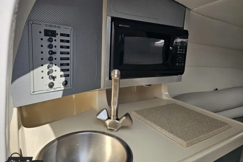 Slide: The Image of 2003 Baja 342 boat interior with microwave, sink, and control panel. - 60