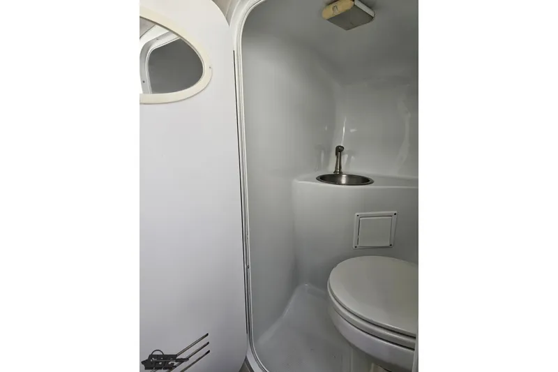 Slide: The Image of Compact bathroom in a 2003 Baja 342 boat, featuring a toilet and sink. - 62