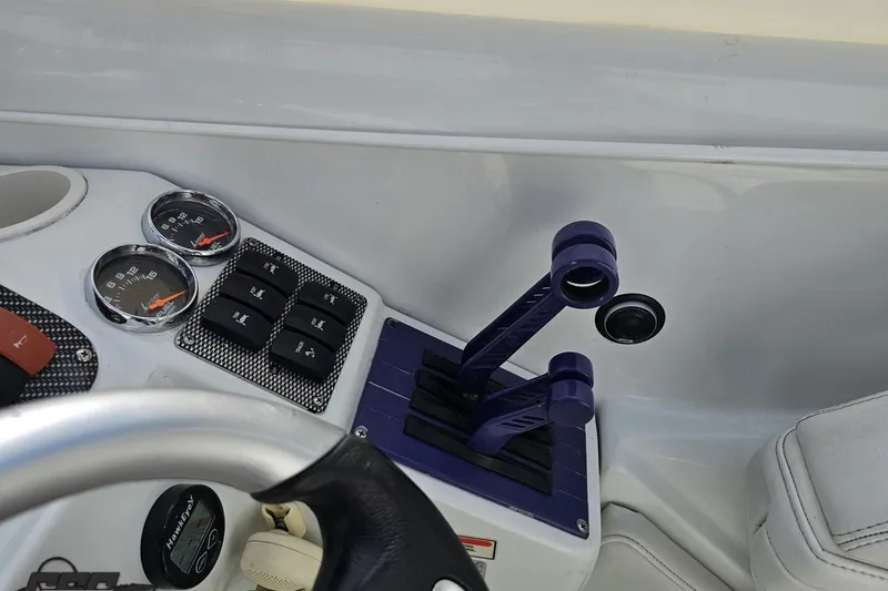 Slide: The Image of Control panel of a 2003 Baja 342 boat with gauges and switches. - 55