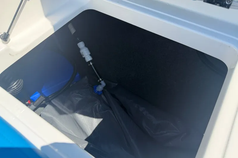 Slide: The Image of Storage compartment of 2023 MasterCraft XT23 boat, featuring internal components and wiring. - 35