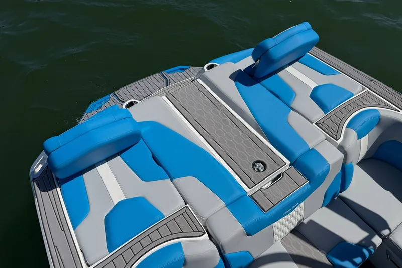 Slide: The Image of 2023 MasterCraft XT23 boat with blue and gray seating on the water. - 30