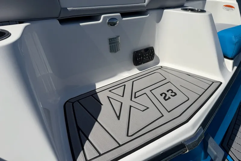 Slide: The Image of 2023 MasterCraft XT23 boat interior with branded flooring and control panel. - 33