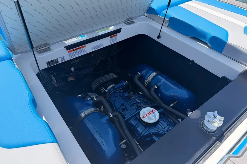 Slide: The Image of 2023 MasterCraft XT23 engine compartment with Ilmor engine, featuring blue accents and open hatch. - 17