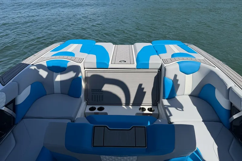 Slide: The Image of 2023 MasterCraft XT23 boat interior with blue and white seating on the water. - 27