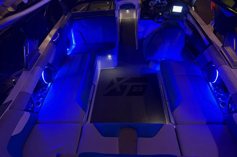 Slide: The Image of 2023 MasterCraft XT23 boat interior with blue LED lighting and modern dashboard. - 45
