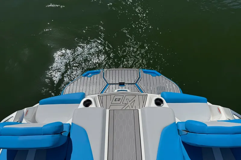 Slide: The Image of 2023 MasterCraft XT23 boat deck with blue seating, overlooking water. - 31