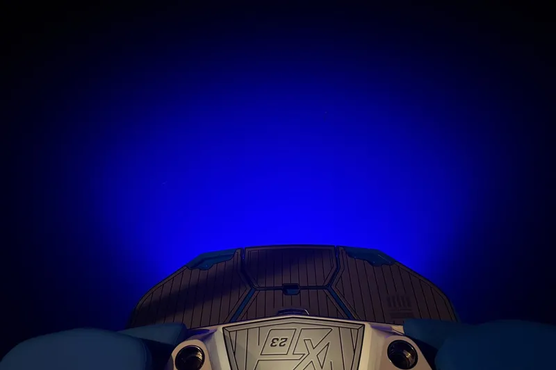 Slide: The Image of 2023 MasterCraft XT23 boat with illuminated blue underwater lighting. - 46