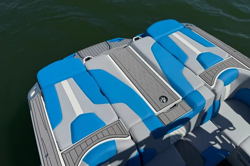 Slide: The Image of 2023 MasterCraft XT23 boat interior with blue and gray seating on water. - 29