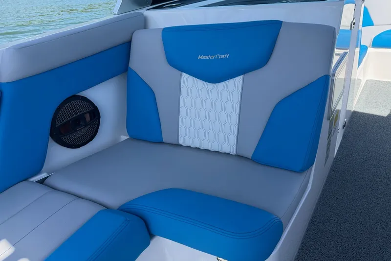 Slide: The Image of 2023 MasterCraft XT23 boat interior with blue and gray seating, featuring stylish design. - 13