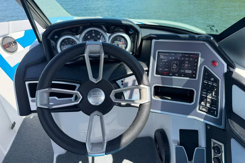 Slide: The Image of 2023 MasterCraft XT23 boat dashboard with steering wheel and digital controls. - 15