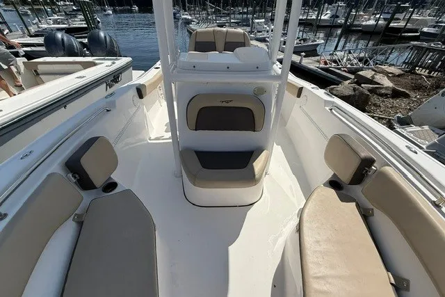Slide: The Image of 2018 Tidewater 220 LXF boat interior with beige seating, docked at marina. - 18