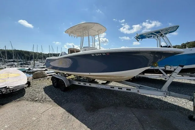 Slide: The Image of 2018 Tidewater 220 LXF boat on trailer at marina under clear blue sky. - 2