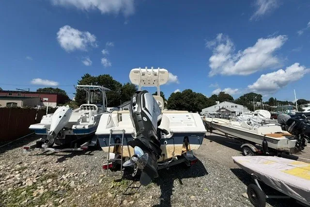 Slide: The Image of 2018 Tidewater 220 LXF boat on a gravel lot under a clear blue sky. - 6