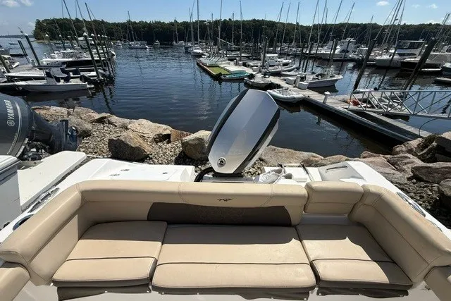 Slide: The Image of 2018 Tidewater 220 LXF boat with seating, docked at a marina with multiple boats. - 9
