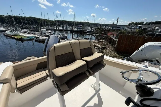Slide: The Image of 2018 Tidewater 220 LXF boat interior with dual seats, overlooking marina. - 17