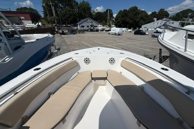 Slide: The Image of 2018 Tidewater 220 LXF boat with beige seating in a marina setting. - 19