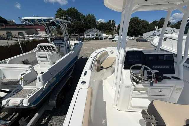 Slide: The Image of 2018 Tidewater 220 LXF boat with console and seating, parked outdoors. - 12