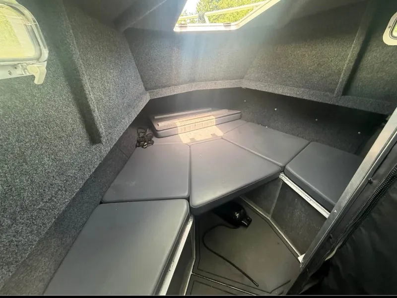 Slide: The Image of Interior of a modern boat with cushioned seating and carpeted walls. - 4