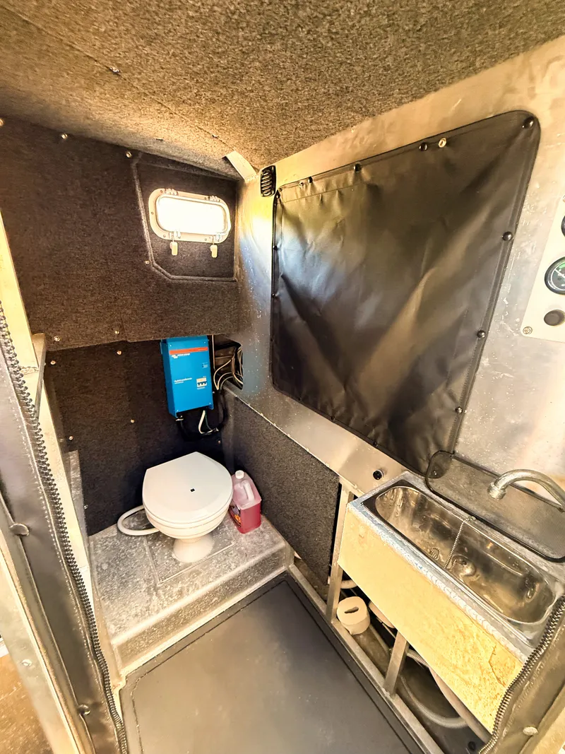 Slide: The Image of Interior of an aluminum patrol boat with a toilet, sink, and small window. - 11
