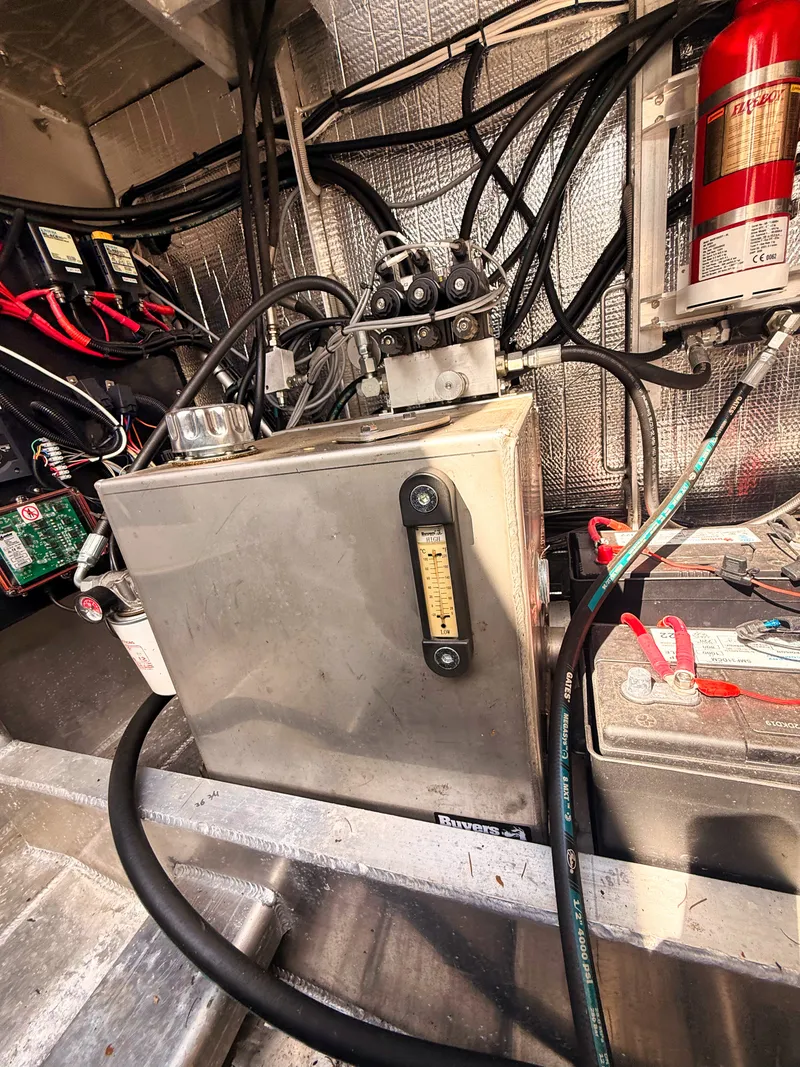 Slide: The Image of Interior view of a boat engine room with wiring, batteries, and a fire extinguisher. - 16