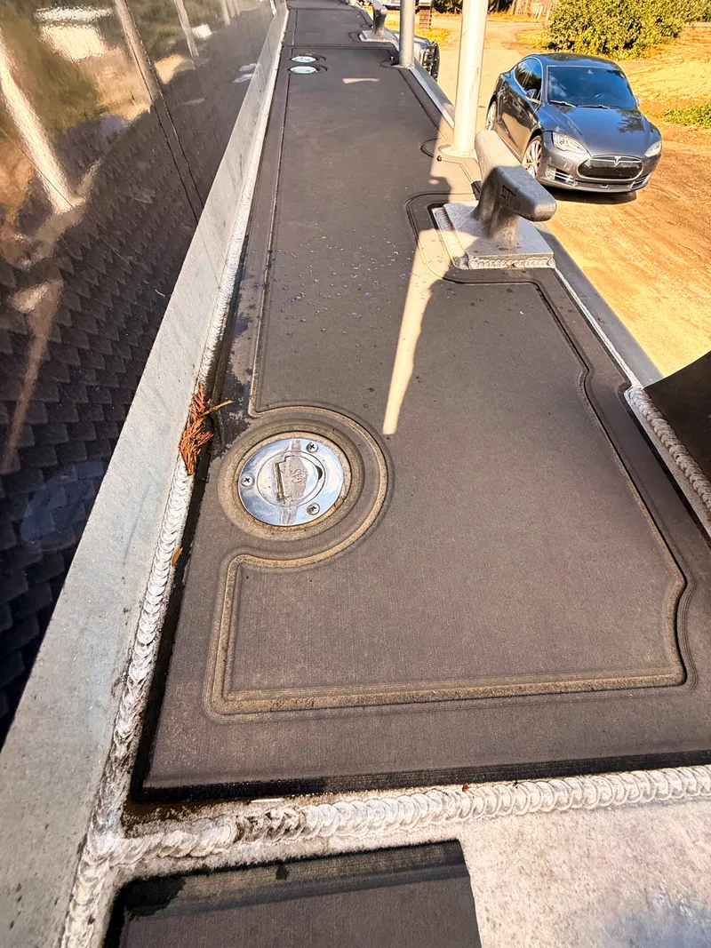 Slide: The Image of The image shows the deck of a Norsco Aluminum Patrol 32 boat with a metal hatch. - 8