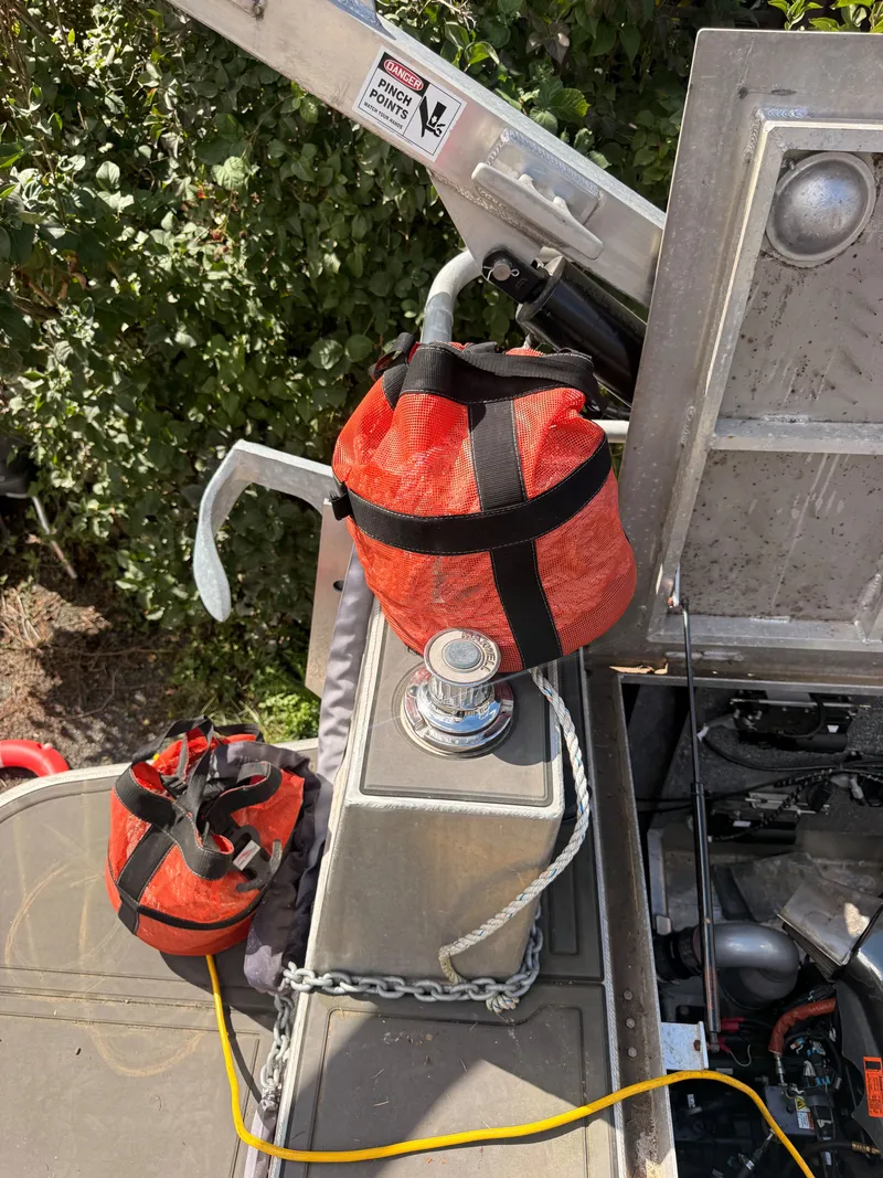 Slide: The Image of A Norsco Aluminum Patrol 32 with a red sea bag and anchor on the deck. - 25