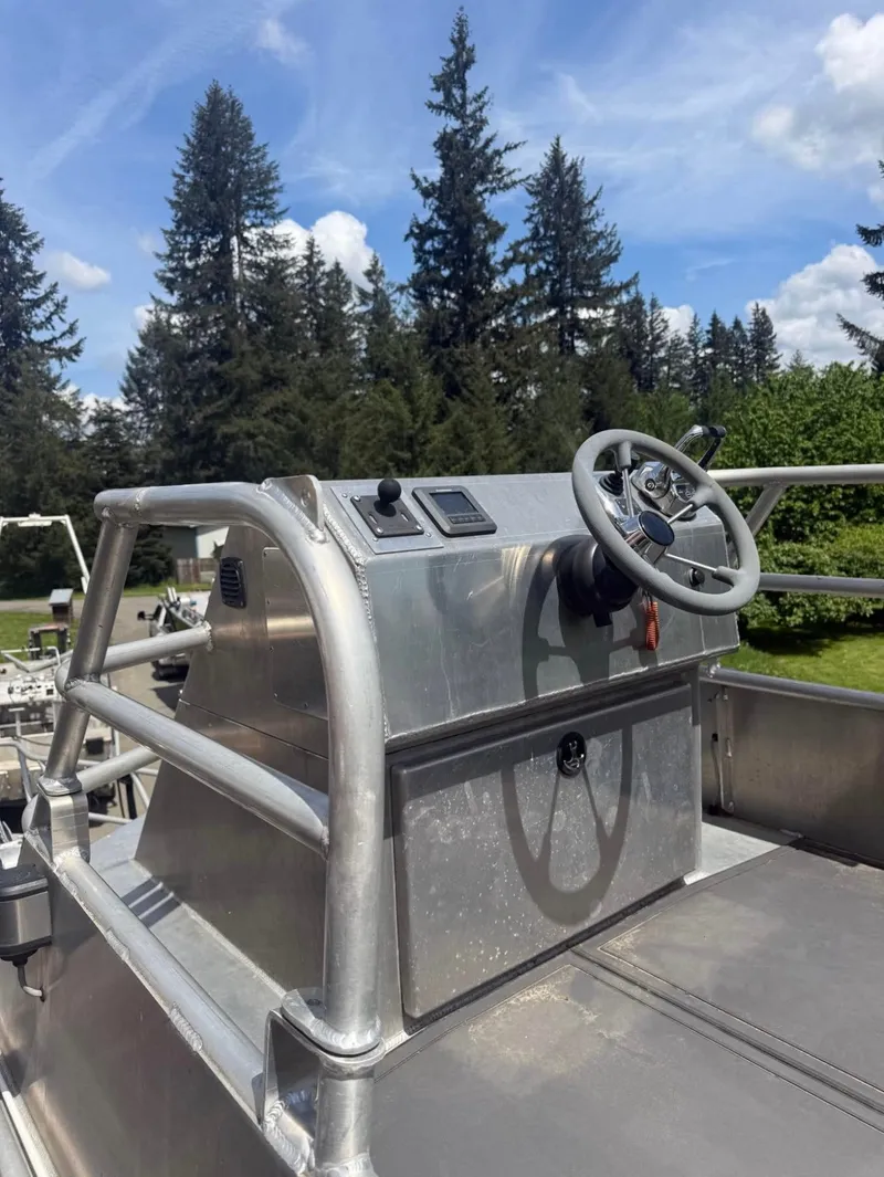 Slide: The Image of An aluminum patrol boat with a helm and steering wheel, surrounded by trees and blue sky. - 1