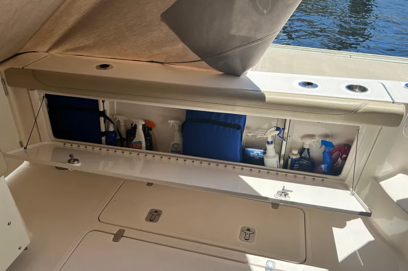 Slide: The Image of Storage compartment on 2018 Pursuit OS 385 Offshore boat, containing cleaning supplies and equipment. - 34