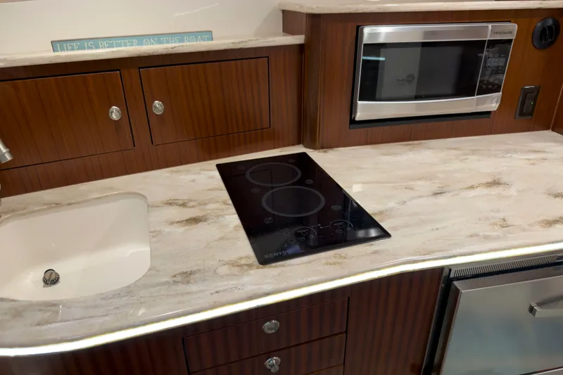 Slide: The Image of Modern kitchen in 2018 Pursuit OS 385 Offshore boat with stove, sink, and microwave. - 17