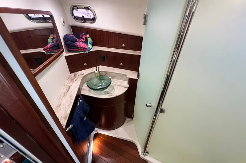 Slide: The Image of Luxurious bathroom in 2018 Pursuit OS 385 Offshore yacht with glass sink and wooden cabinetry. - 16